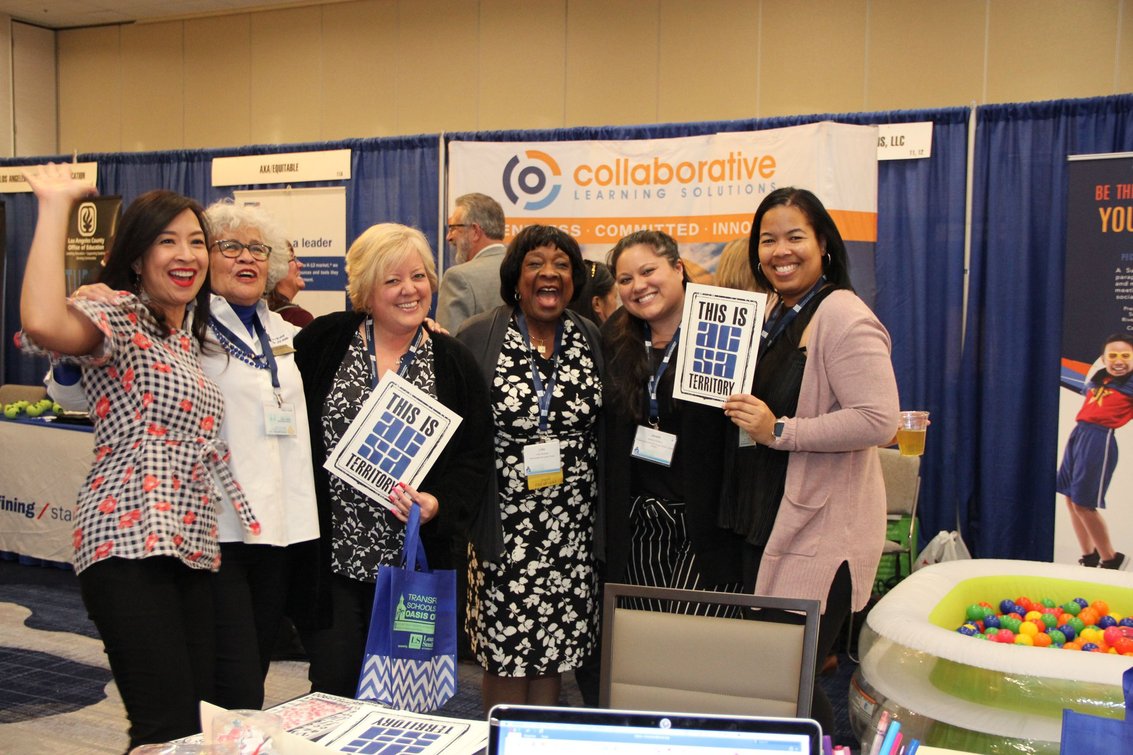ACSA staff and members at an event, holding up This is ACSA territory signs.