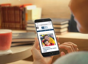 A hand holding an iPhone showing EdCal's online version.